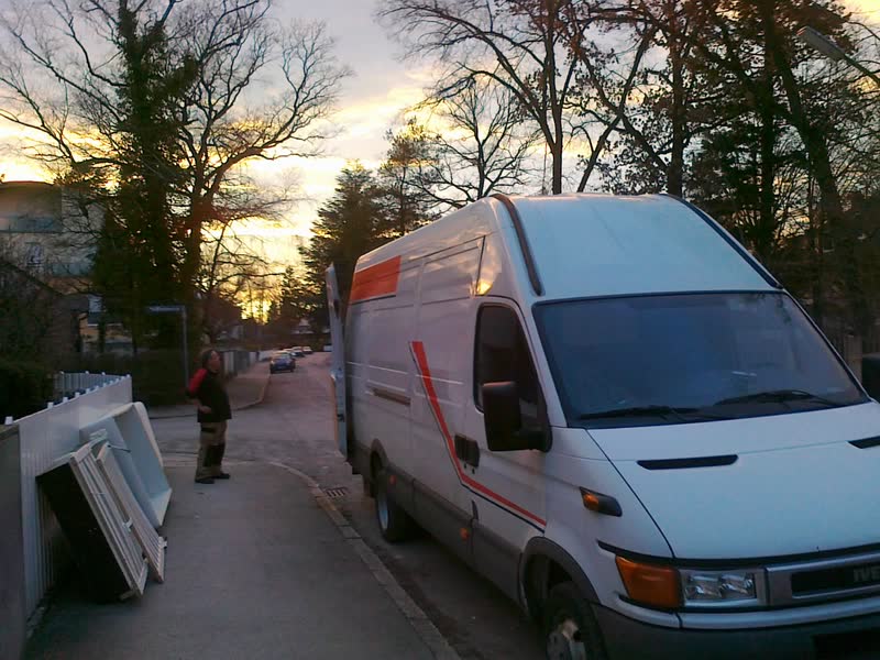 Weißer Transporter bei der Beladung am Straßenrand in der Abendsonne